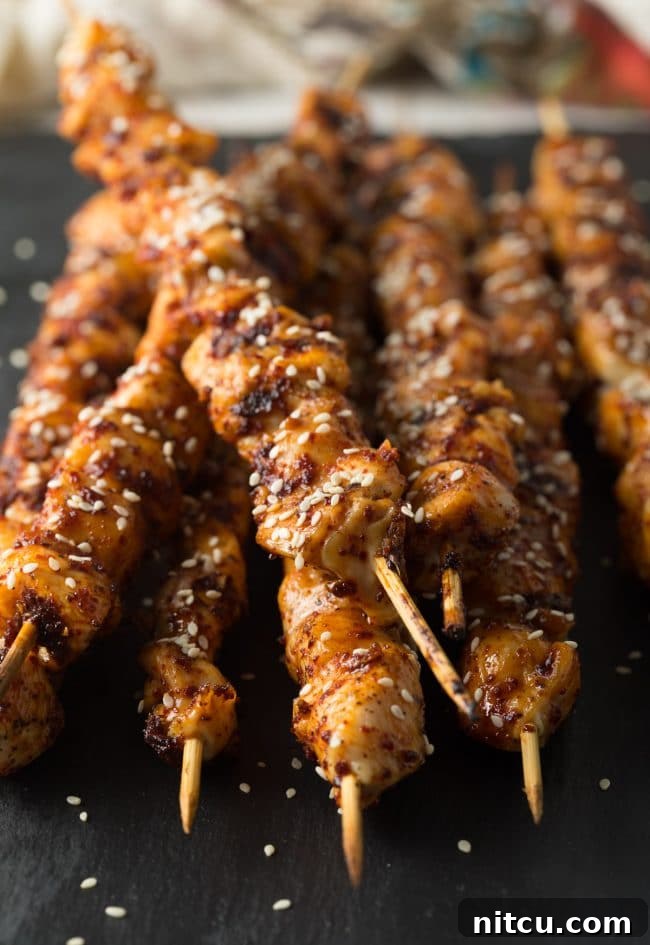 Gochujang Glazed Chicken Skewers 9 Close-up shot of grilled Korean chicken skewers on a serving board.