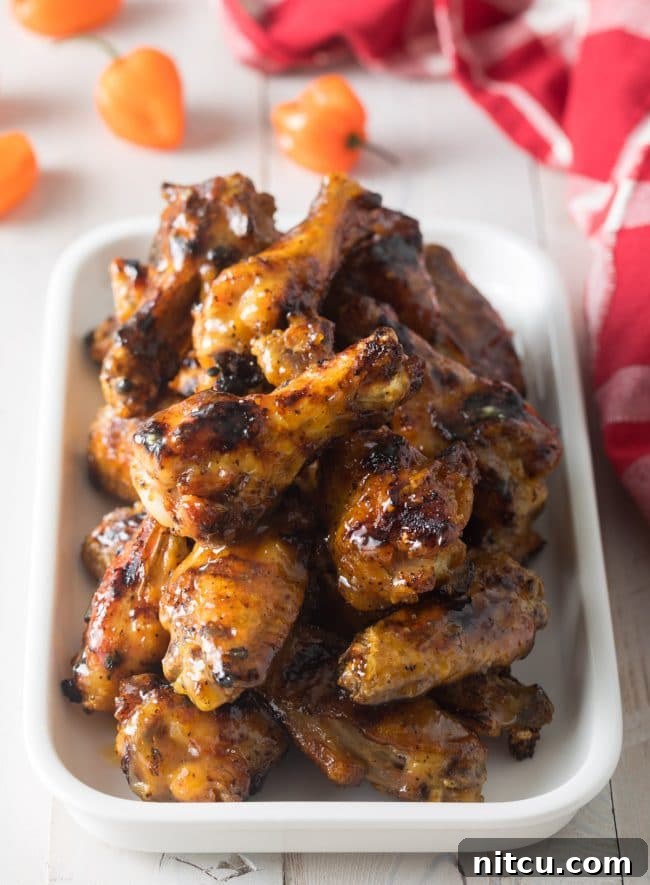 Peach Habanero Flame Wings 2 White rectangle dish loaded with grilled habanero peach chicken wings.
