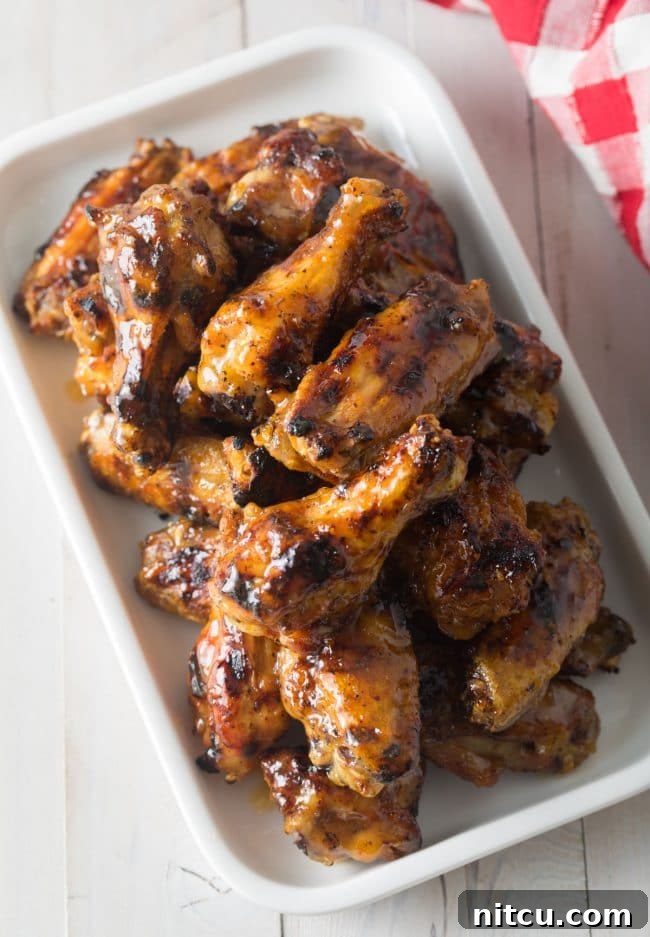 Peach Habanero Flame Wings 7 White rectangle dish brimming with glazed grilled habanero peach chicken wings.