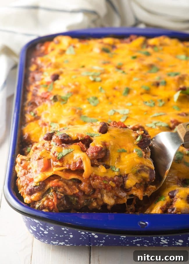 Baked Zesty Cowboy Lasagna Recipe in a casserole dish, showcasing perfectly melted cheese and hearty layers of beans and meat