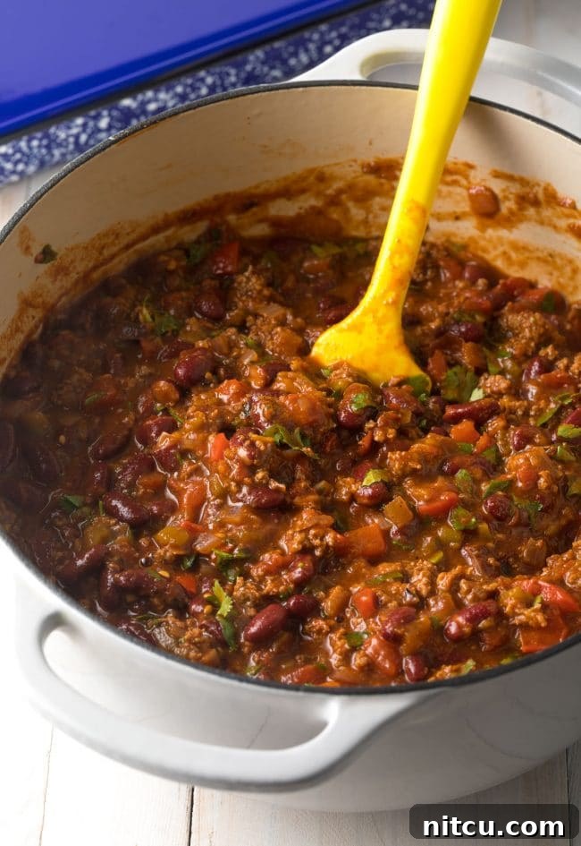 Rich Cowboy Chili simmering in a large pot, forming the flavorful base for the lasagna