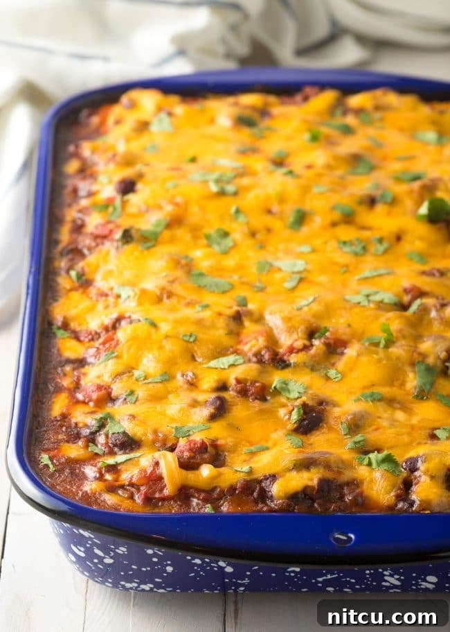 Perfectly baked Cowboy Lasagna recipe in a pan, featuring a bubbling, golden melted cheese topping, fresh out of the oven