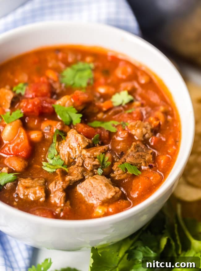 Brewmaster's Chili 7 A rustic white bowl brimming with hearty steak chili and beans, capturing the comforting essence of a perfect homemade meal.