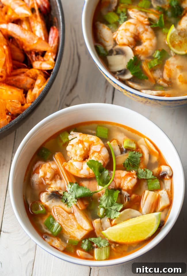 Spicy Thai Tom Yum Soup 12 Another overhead shot of two delectable bowls of shrimp Tom Yum soup, beautifully presented and ready to be savored.