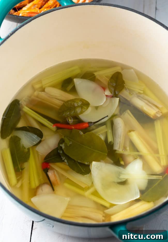 Spicy Thai Tom Yum Soup 8 Aromatic kaffir lime leaves and stalks of lemongrass infusing in a simmering broth, releasing their fragrant essences.