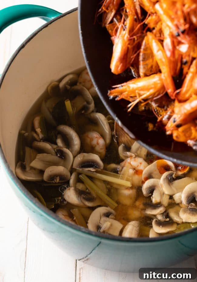 Spicy Thai Tom Yum Soup 9 Cooked shrimp are added to a pot of Tom Yum soup, joining mushrooms and fragrant lemongrass, just before serving.