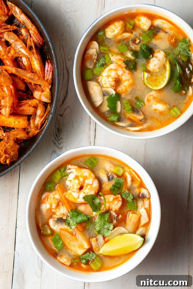 Spicy Thai Tom Yum Soup 10 An overhead shot showcasing two bowls of beautifully plated shrimp Tom Yum soup, ready to be enjoyed.