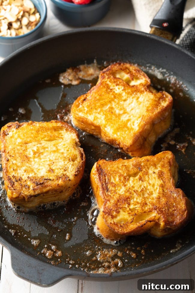 Golden Fluffy French Toast Perfection 8 3 pieces of pain perdu on a hot skillet.