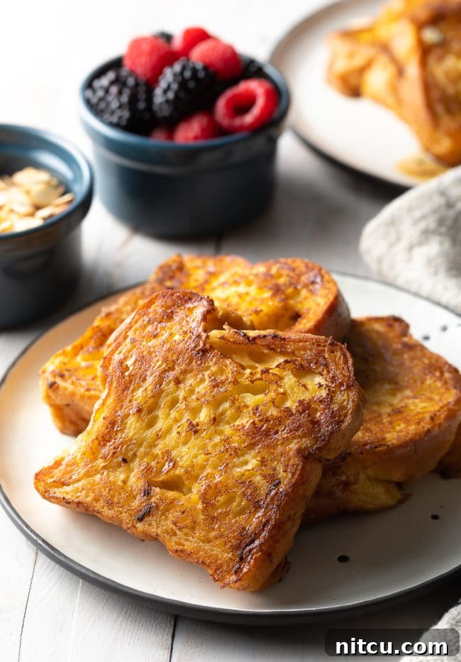 Golden Fluffy French Toast Perfection 9 Slices of pain perdu on a white plate.