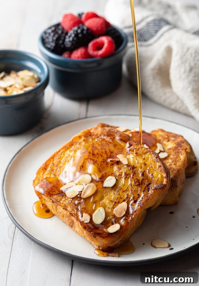 Golden Fluffy French Toast Perfection 10 Two slices of pain perdu with maple syrup drizzling on top.