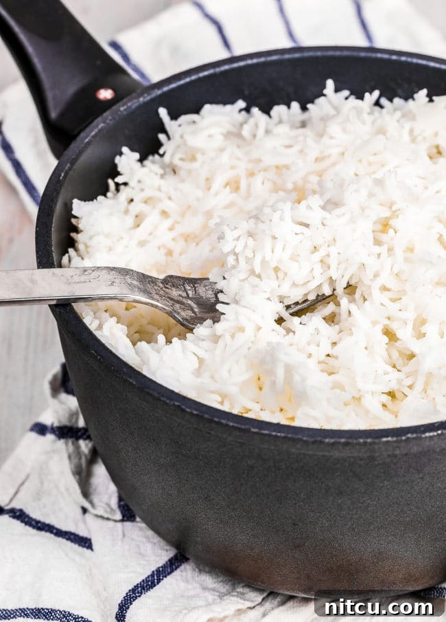Basmati Rice Cooking - A fork fluffing basmati rice in a pot.