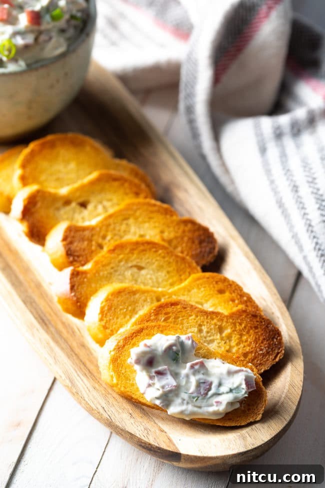 Piece of crostini with a dollop of chipped beef dip on it. 