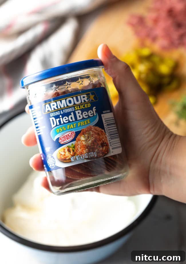 Hand holding a jar of dried beef to camera. 