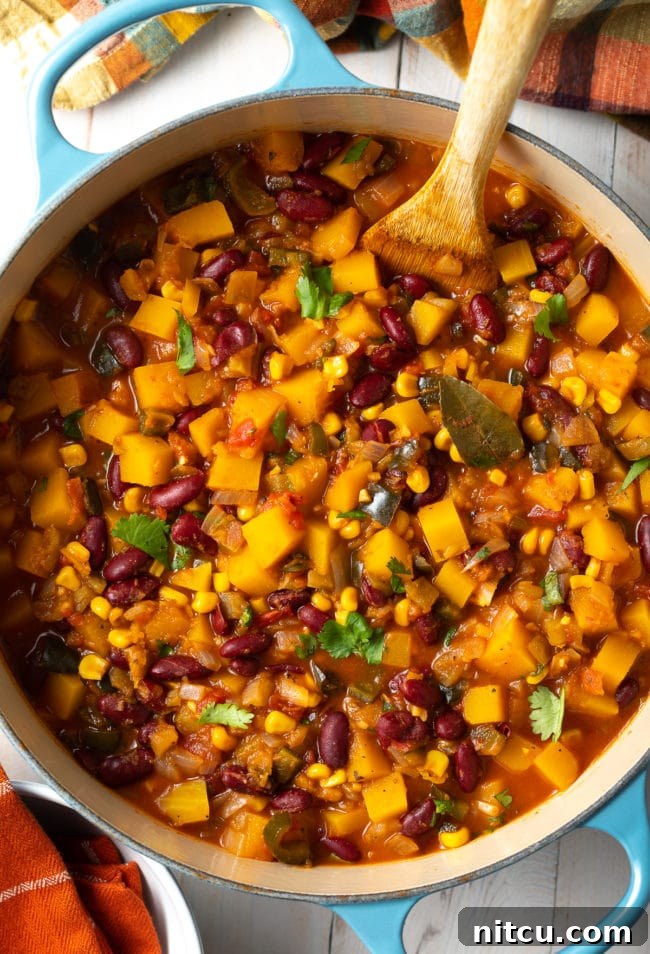 Hearty Butternut Chili 2 Vibrant Butternut Squash Chili, slow-cooked to perfection, in a large rustic pot, ready to be served.