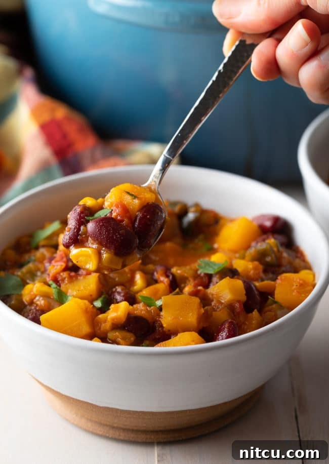 Hearty Butternut Chili 11 A spoonful of slow cooker vegetarian chili, showing its thick texture and wholesome ingredients.