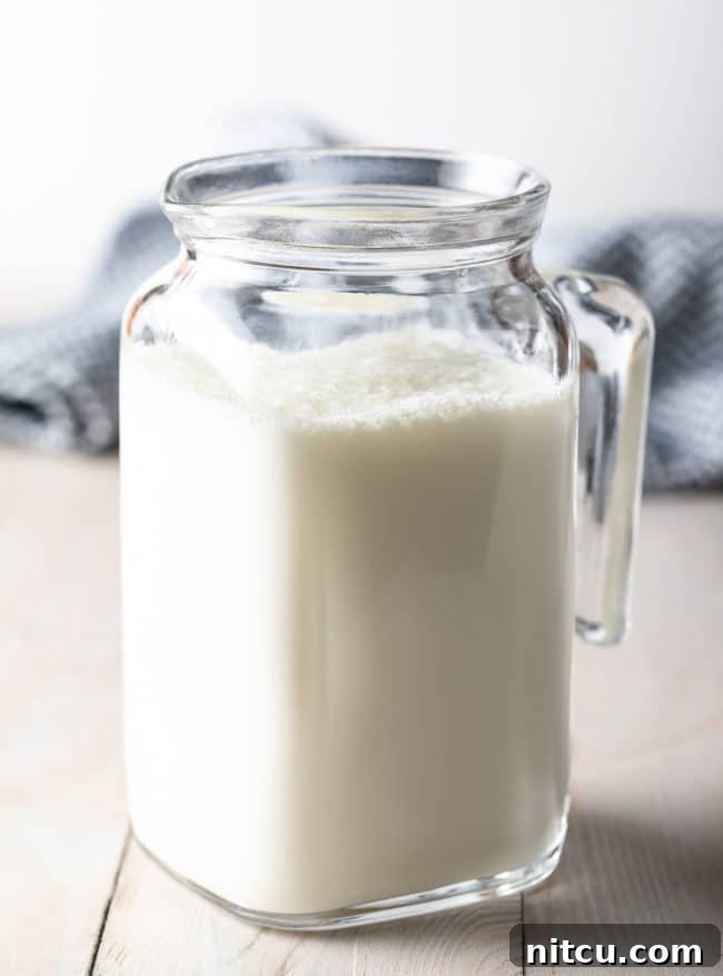 Whipping Up Buttermilk At Home 2 A charming glass pitcher filled with freshly made homemade buttermilk, ready for use.