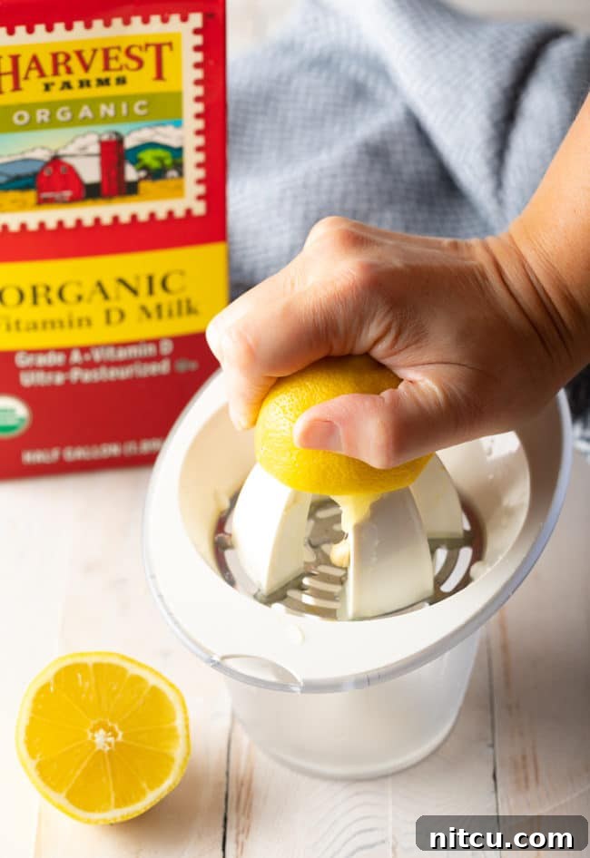 Whipping Up Buttermilk At Home 4 A hand expertly using a lemon juicer to extract fresh lemon juice into a bowl.