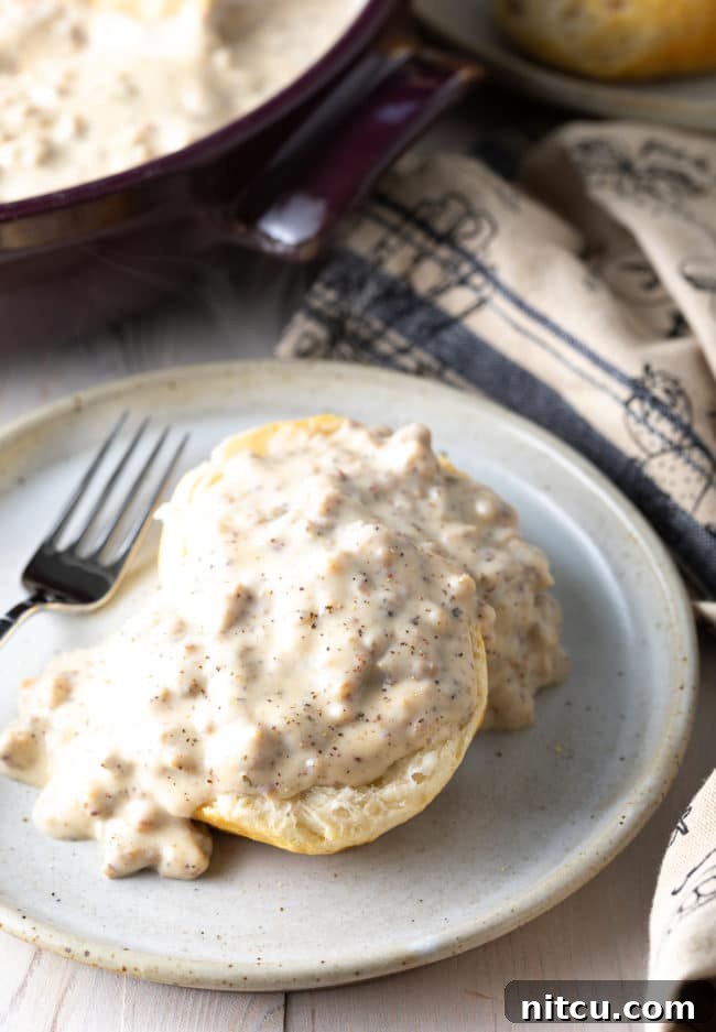 Effortless Homemade Sausage Gravy 7 fluffy cathead biscuits covered in white sausage gravy