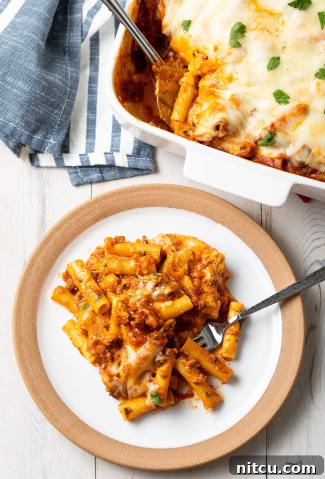 baked-ziti-with-sausage serving of baked ziti with Italian sausage on a white plate