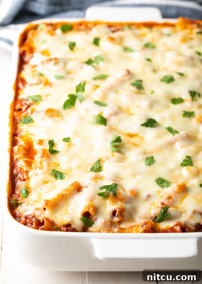 no-boil-pasta-baked-ziti Baked ziti with Italian sausage baking in a casserole dish, showing the no-boil pasta