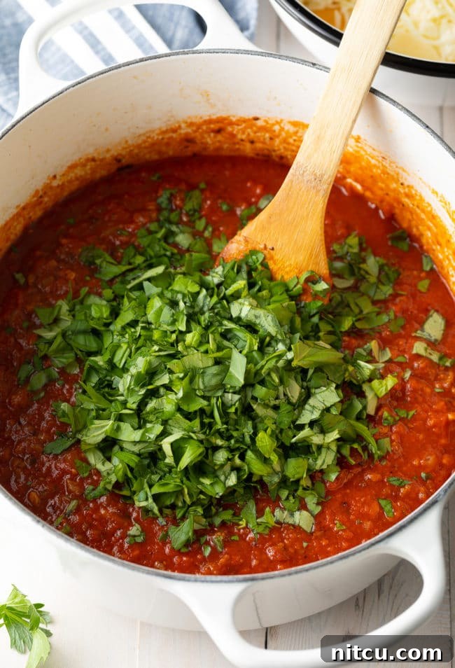 Italian-pasta-sauce meat sauce with sausage simmering in a pot for baked ziti recipe