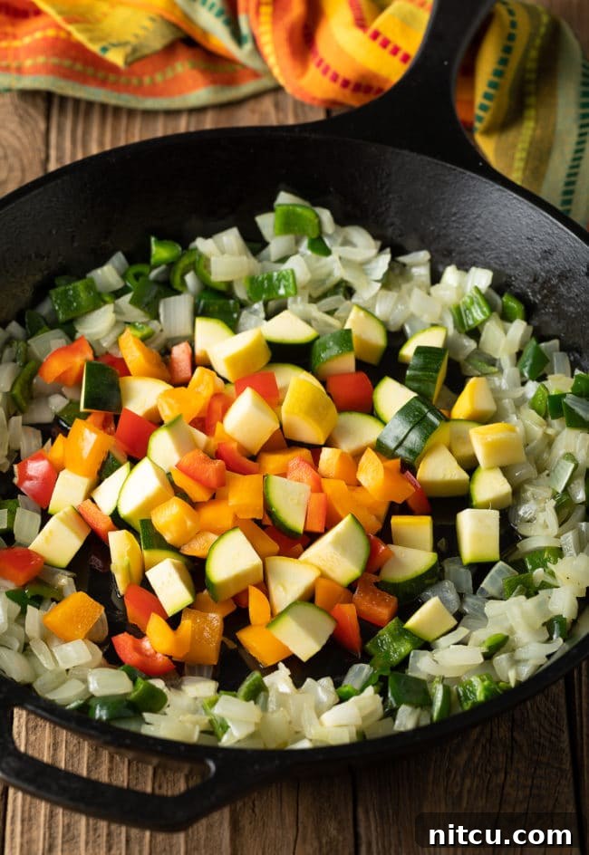 Sautéing vegetables in a cast iron skillet, a key step in How To Make Calabacitas Con Queso Recipe.
