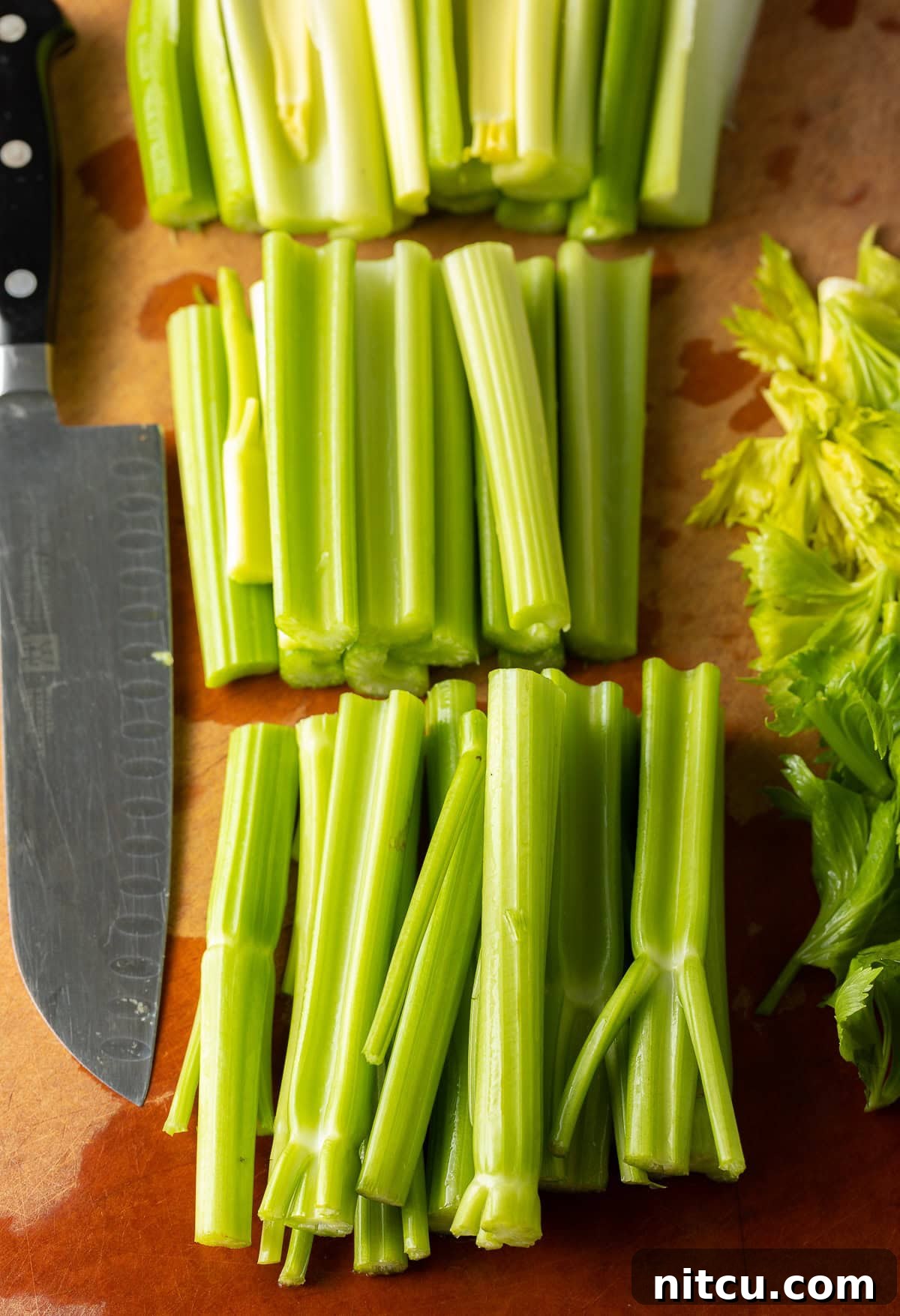 Homemade Celery Juice for Wellness 5 Washed and trimmed celery stalks on a cutting board.