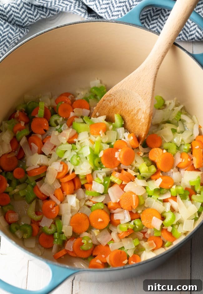 Step-by-step: Sautéing vegetables in a Dutch oven for creamy lemon chicken soup.