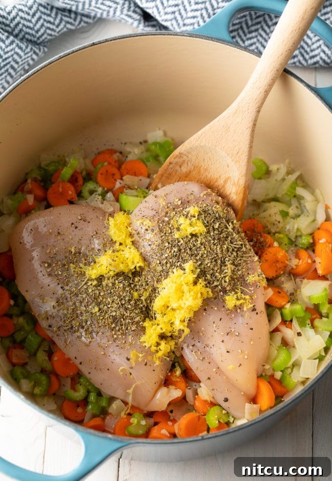 Step-by-step: Adding chicken, broth, and lemon zest to the sautéed vegetables in a Dutch oven.