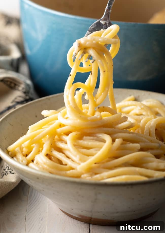 Easy One-Pot Cacio e Pepe Recipe with pasta swirled on a fork in a bowl.