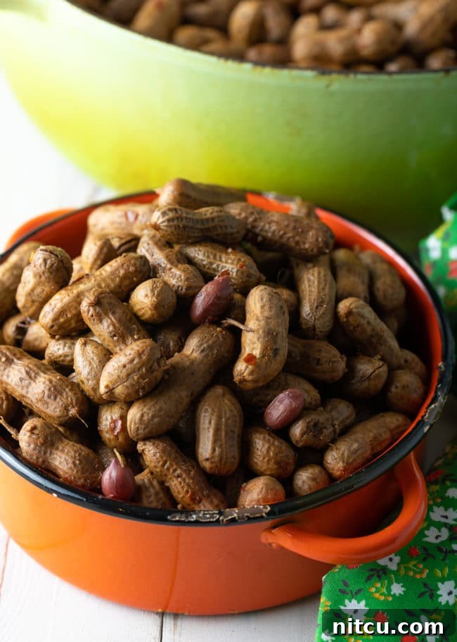 Perfect Boiled Peanuts 12 Boiled peanuts in an orange pot next to a larger pot with more peanuts in it.