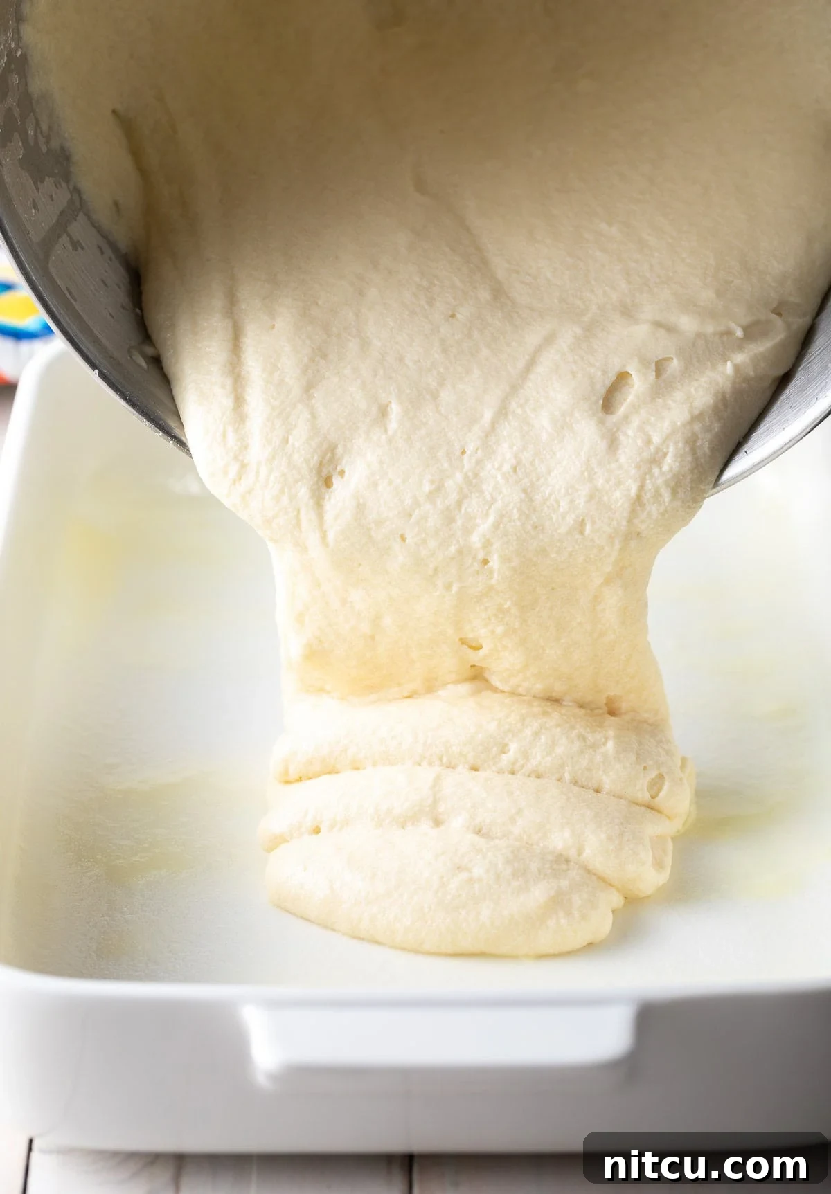 Fluffy Vanilla Cake From Scratch 8 Cake batter being smoothly poured into a meticulously prepared baking dish.