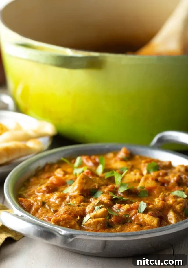 Fiery Madras Chicken 4 Madras Curry with chicken in a bowl with cilantro on top.