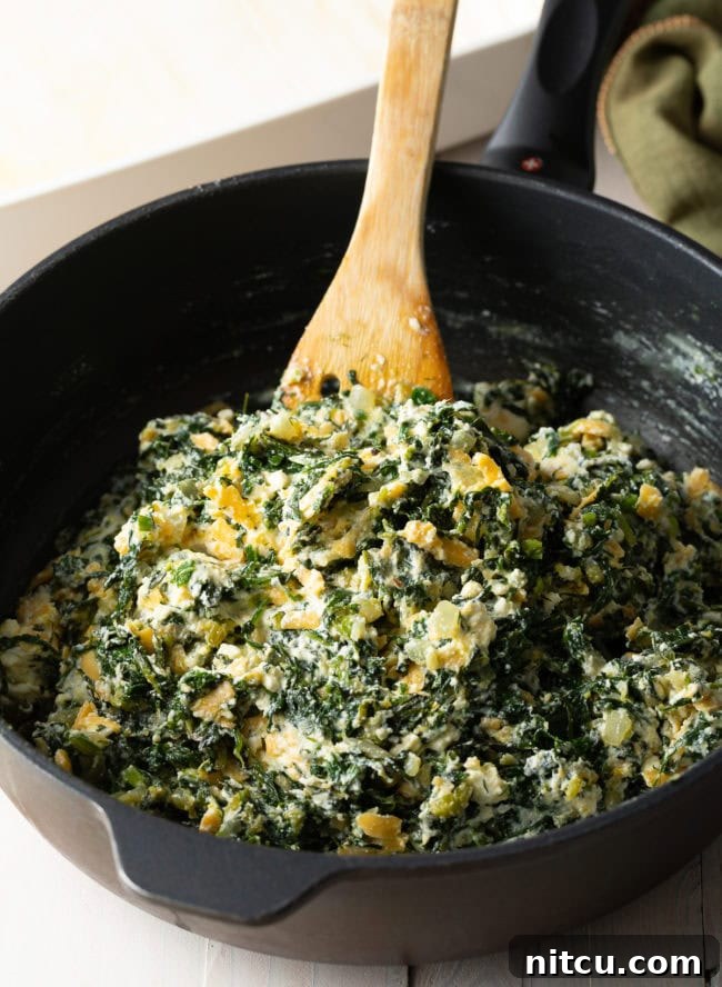 Savory Spinach Pie 8 The vibrant green spinach and herb filling, perfectly mixed with the three cheeses and eggs, prepared in a pan and ready to be spread into the phyllo crust.