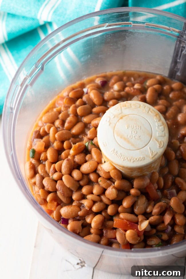 Ultimate Homemade Bean Dip 6 Pinto beans in a food processor bowl, before being blended into a smooth dip.