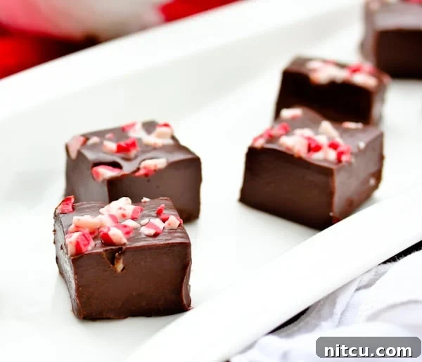 Peppermint Fudge cut into pieces on a platter, ready to be enjoyed.
