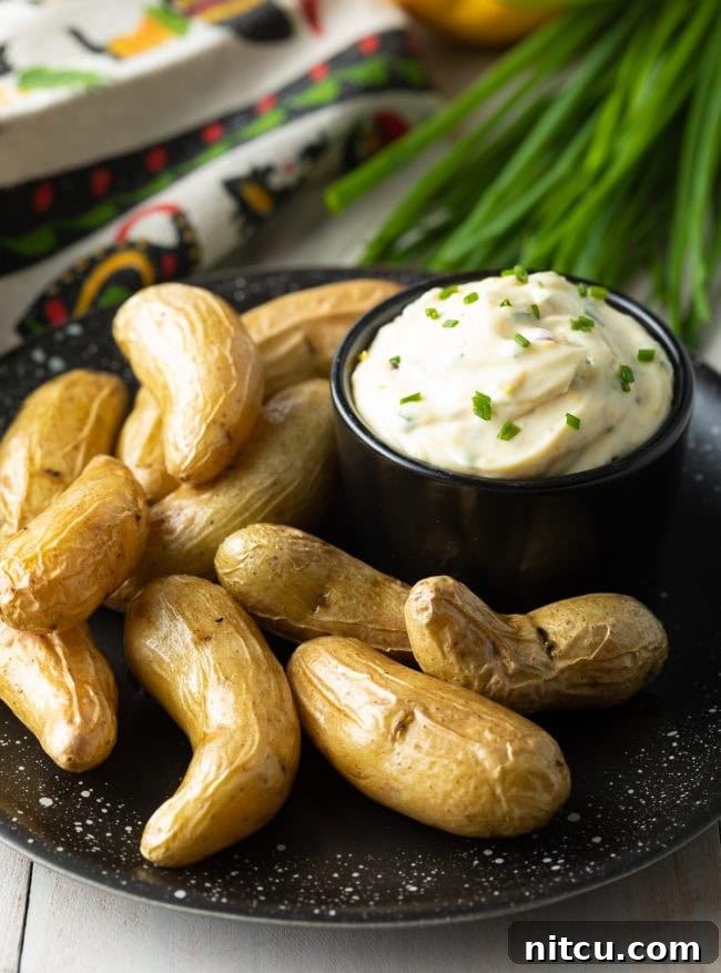 Enchanted Aioli 4 A bowl of garlic aioli on a plate with fingerling potatoes.