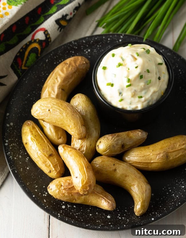 Enchanted Aioli 7 Aioli sauce in a bowl with a plate of fingerling potatoes.