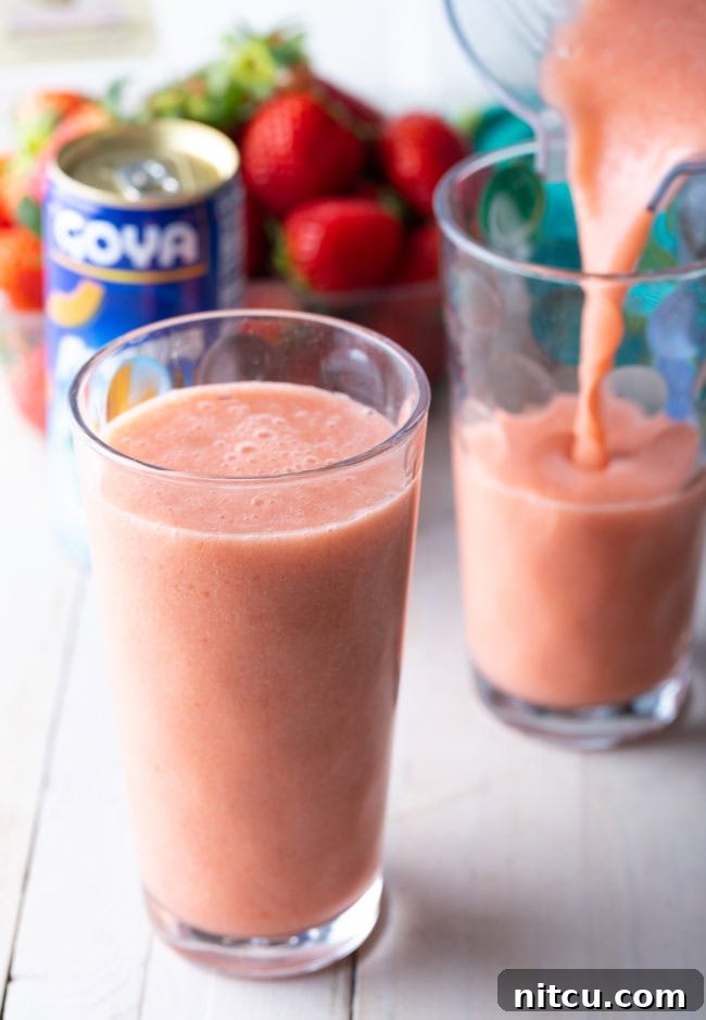 Smoothie King Caribbean Way: Your Tropical Getaway Recipe 7 Caribbean Way Smoothie in a glass with another glass being filled.