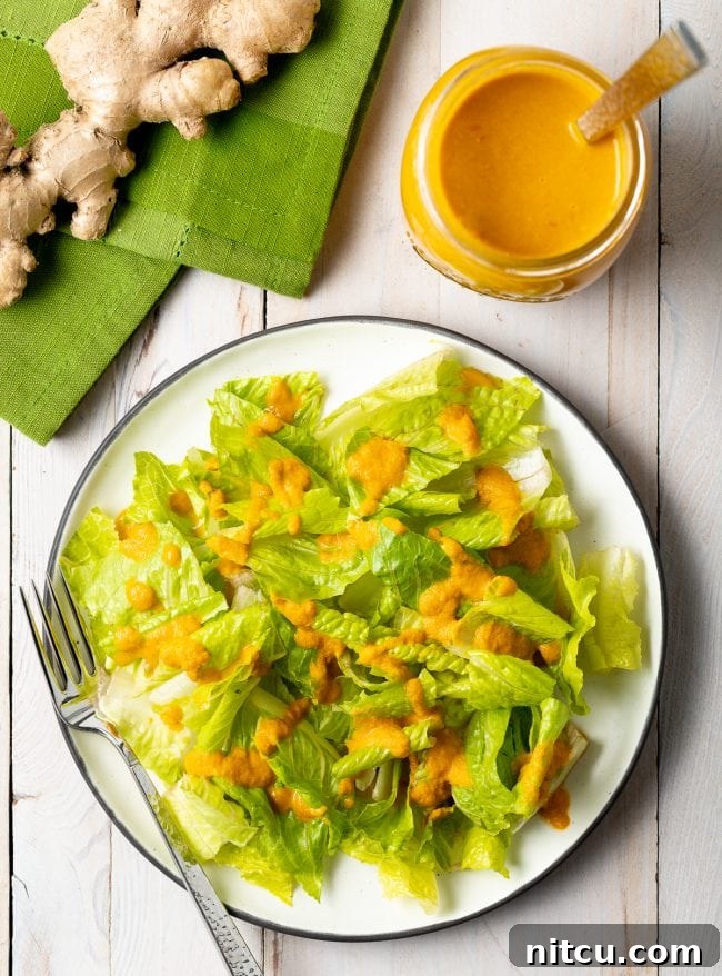 Vibrant Ginger Sesame Dressing 2 Overhead shot of romaine lettuce with drizzle of ginger salad dressing on top. A vibrant, homemade Japanese Ginger Dressing transforming a simple salad.