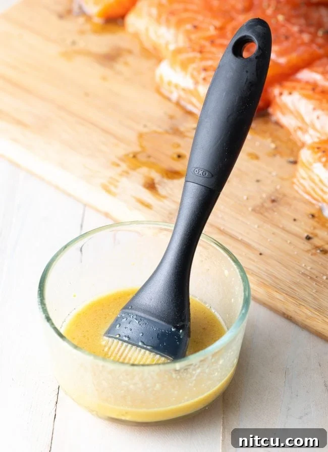 Pineapple Glazed Salmon Delight 7 Prepped marinade in a glass bowl with a brush.