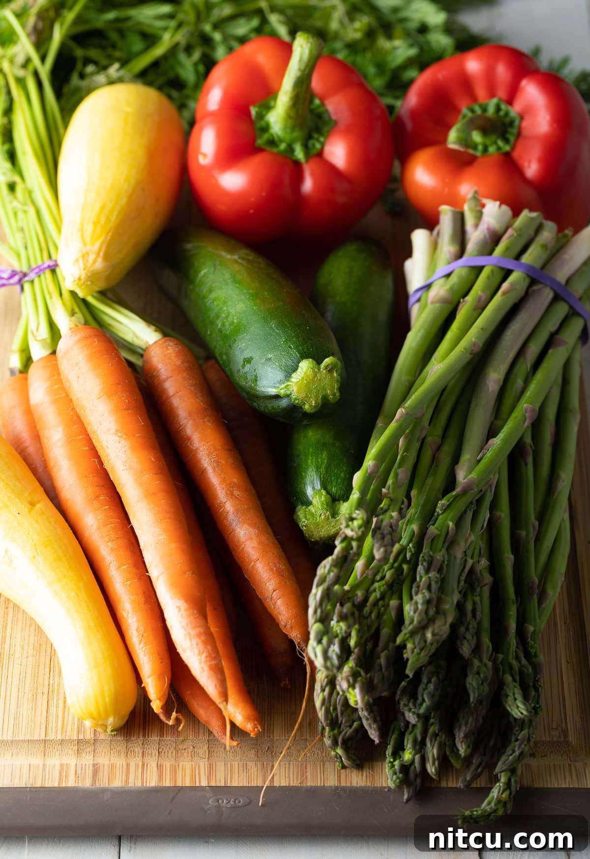Perfect Grilled Vegetable Marinade 5 An assortment of fresh, raw vegetables ready for grilling, including carrots, asparagus, zucchini, and bell peppers.