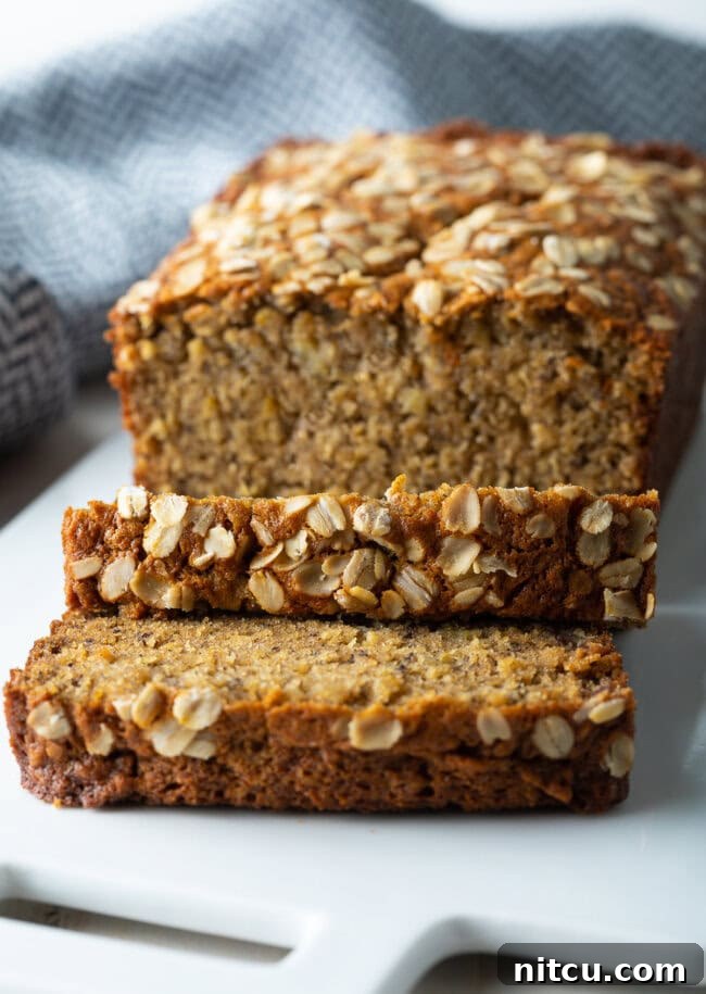 Wholesome Oat & Banana Loaf 12 A delectable loaf of Oatmeal Banana Bread with multiple slices cut off, showcasing its moist interior.