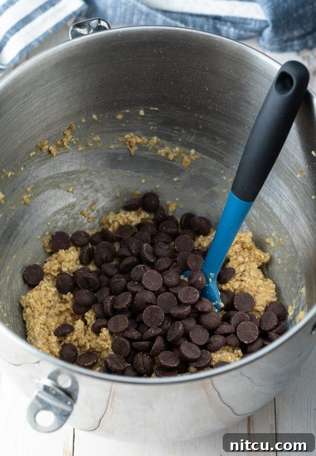 Banana Bread Bliss Chocolate Chip Cookies 7 Cookie batter in a mixing bowl with chocolate chips being folded in.