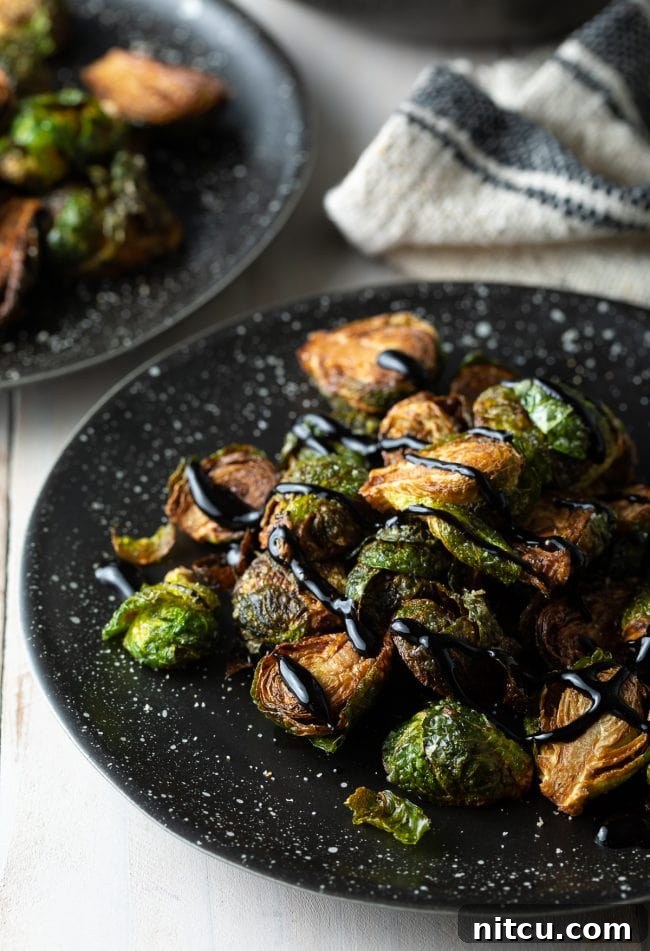 Crispy Golden Brussels Sprouts 9 Plate of Brussels sprouts topped with balsamic glaze, beautifully plated.