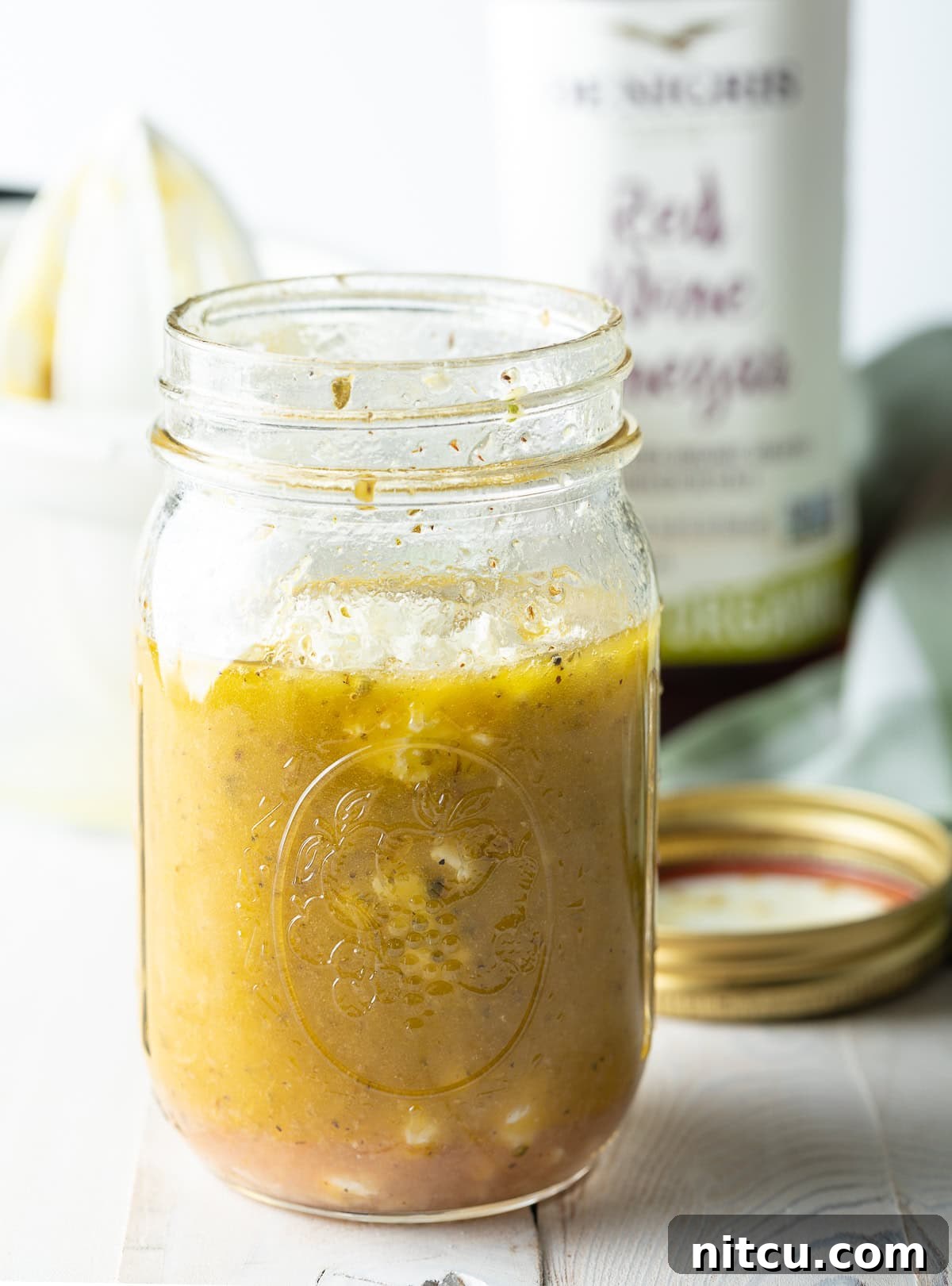 Zesty Greek Vinaigrette 4 A glass jar filled with Mediterranean Salad Dressing, showcasing its appealing color and texture.