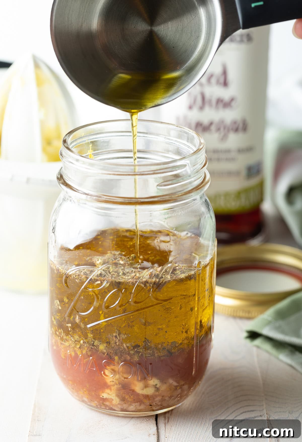 Zesty Greek Vinaigrette 6 Fresh lemon zest being added to a measuring cup, emphasizing the importance of citrus in Greek dressing.