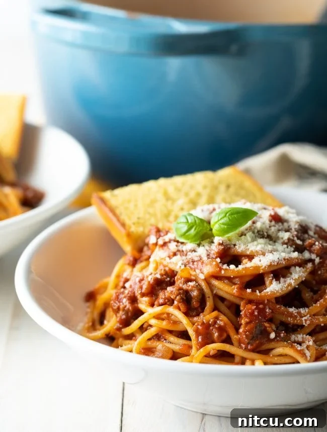 The Ultimate Spaghetti and Meat Sauce 4 Spaghetti with meat sauce in a bowl served with garlic bread.