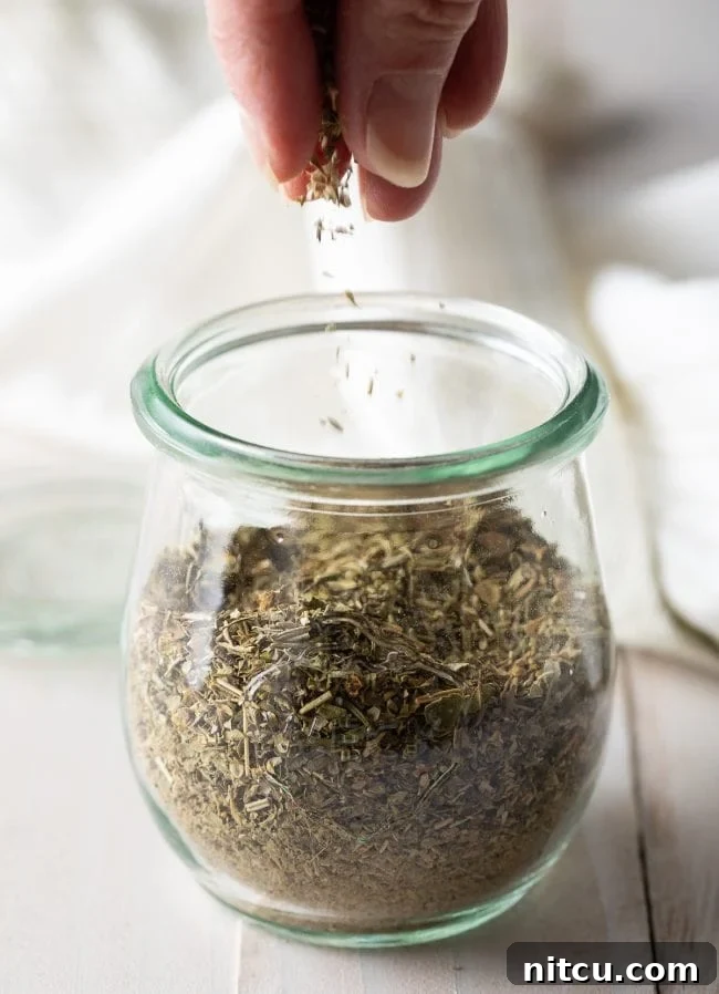 Your Signature Italian Spice Blend 2 Homemade Italian seasoning in a glass jar, ready for use in cooking.