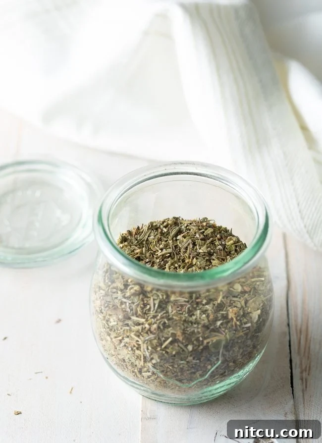 Your Signature Italian Spice Blend 7 A mix of dried herbs forming the base of Italian seasoning, scattered on a surface.